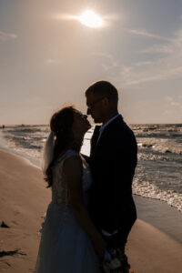 Sesja poślubna nad morzem o zachodzie słońca